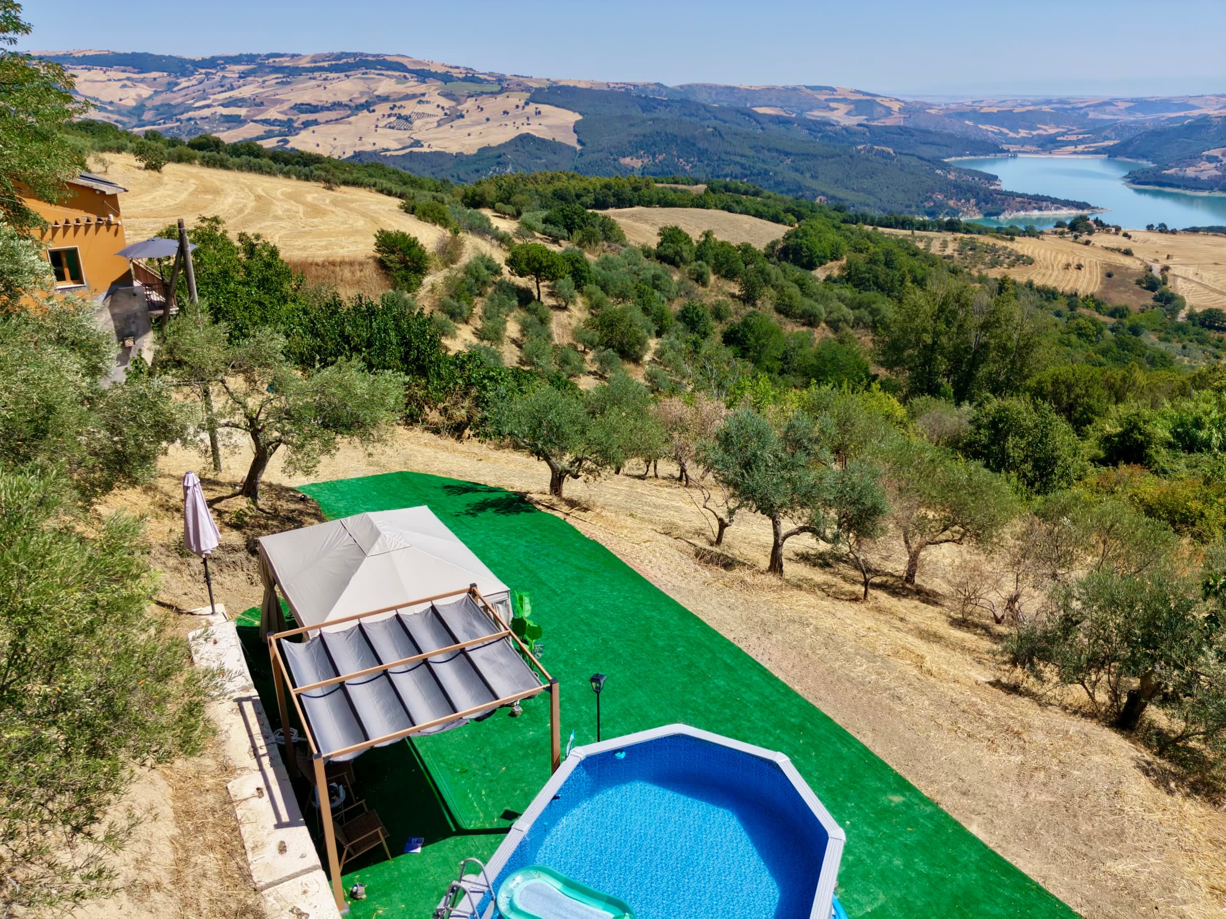 The pool and pergola at Casa del Juniper with Lake Occhito in the distance